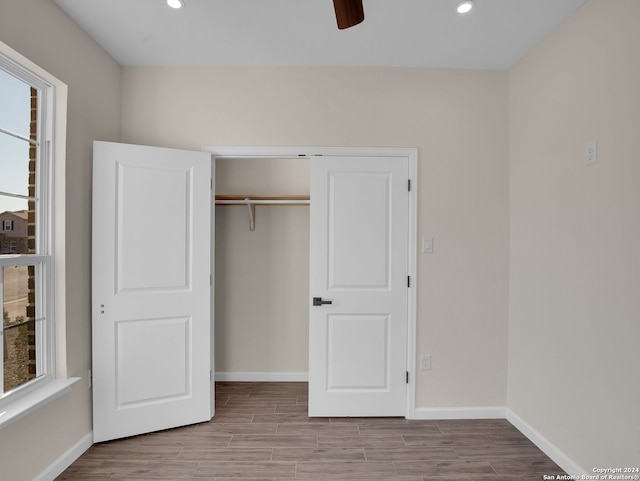 unfurnished bedroom with ceiling fan, multiple windows, and a closet