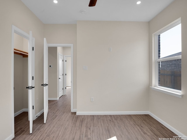 empty room with light hardwood / wood-style floors and ceiling fan