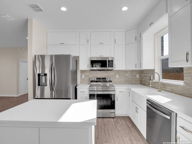 kitchen featuring white cabinetry, sink, appliances with stainless steel finishes, and tasteful backsplash