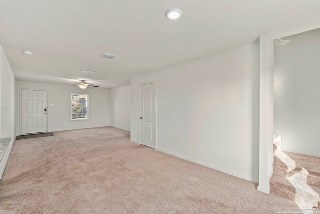 empty room featuring ceiling fan and light colored carpet