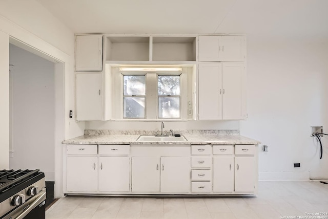 kitchen with white cabinets, stainless steel range with gas cooktop, and sink