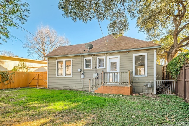 rear view of house featuring a lawn