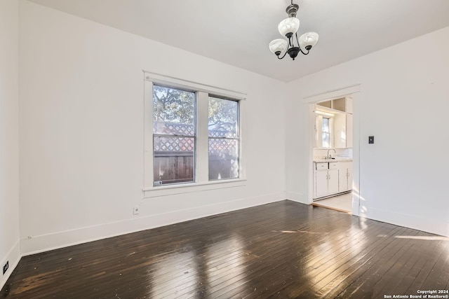 unfurnished room featuring a chandelier, dark hardwood / wood-style flooring, and sink