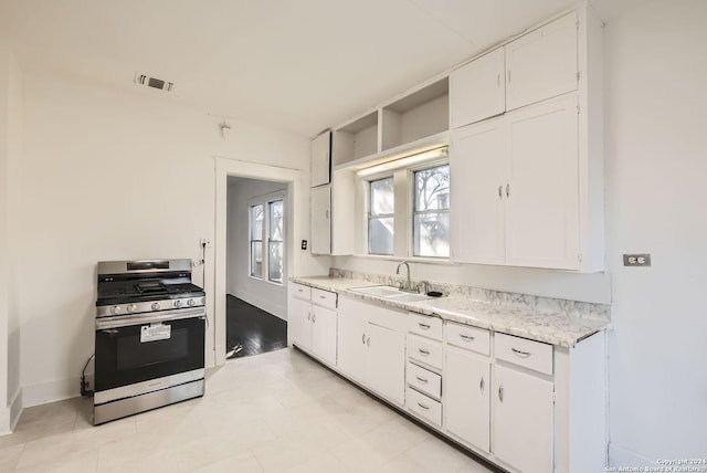 kitchen featuring white cabinetry, sink, and stainless steel range