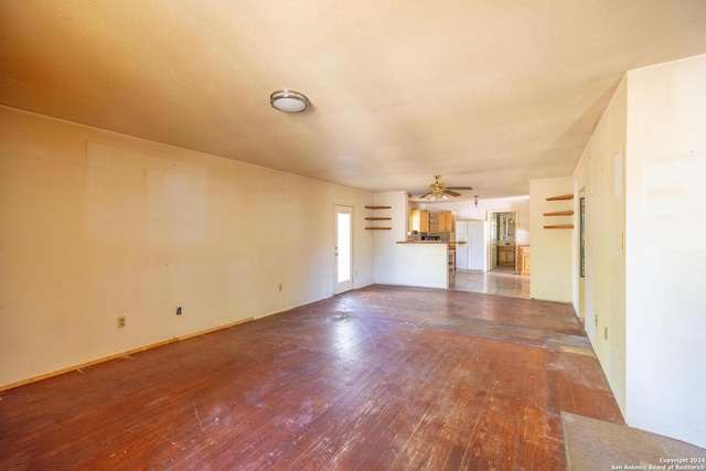 unfurnished living room featuring ceiling fan and dark wood-type flooring