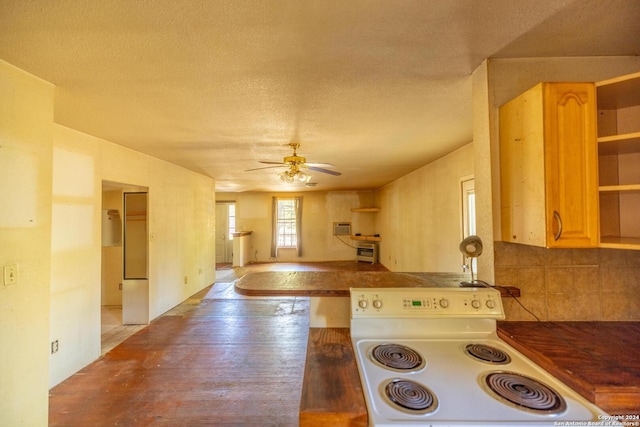 kitchen featuring light brown cabinets, white electric stove, ceiling fan, a textured ceiling, and kitchen peninsula