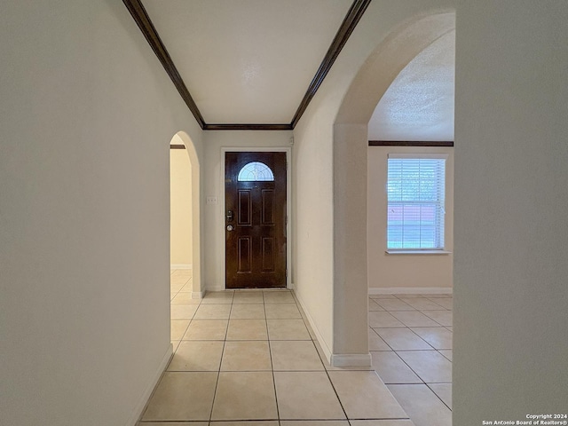 doorway featuring light tile patterned flooring, crown molding, and a wealth of natural light