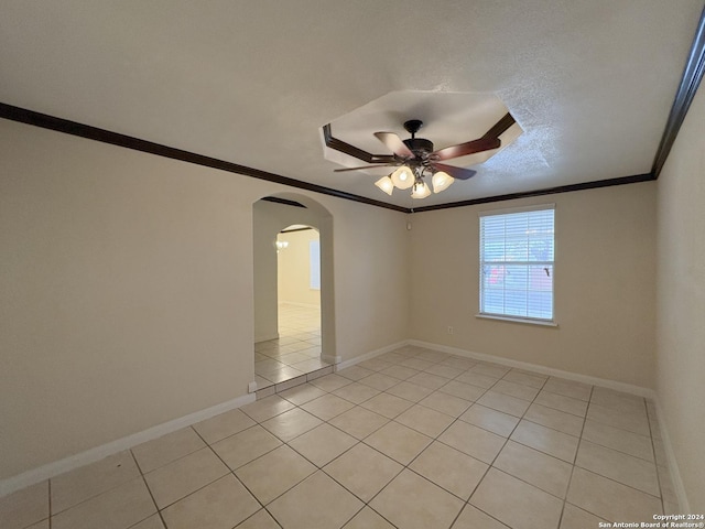 unfurnished room featuring ceiling fan, ornamental molding, a textured ceiling, and light tile patterned floors