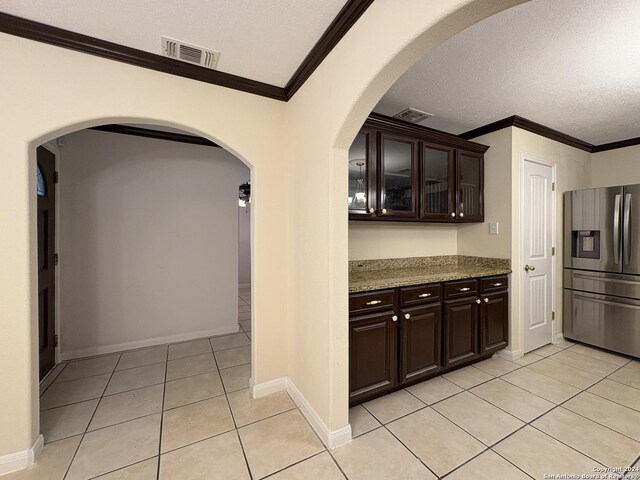 kitchen featuring dark brown cabinets, stainless steel fridge, and a textured ceiling