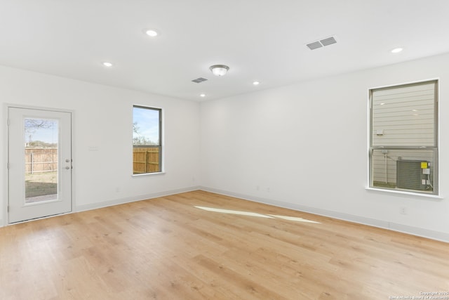 empty room featuring visible vents, baseboards, light wood finished floors, and recessed lighting