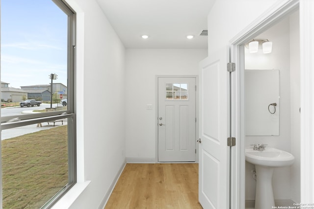 entryway with light wood-style flooring, recessed lighting, a wealth of natural light, and baseboards