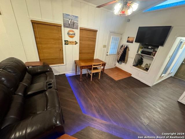 living room with ceiling fan and dark hardwood / wood-style floors