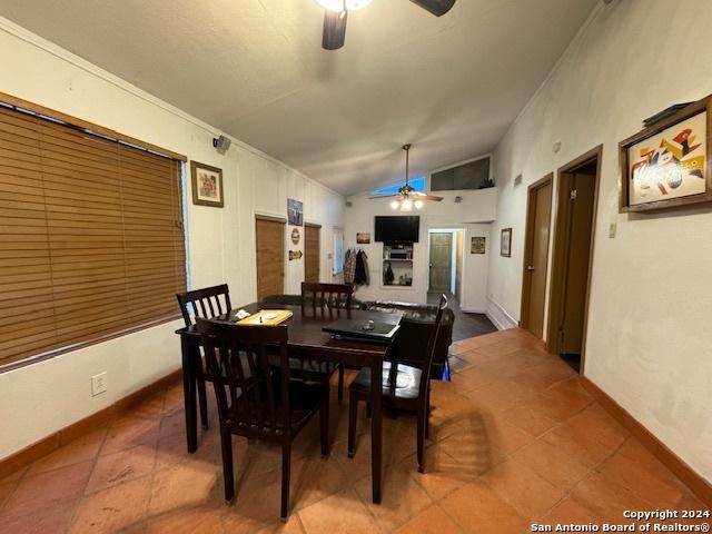 tiled dining space featuring ceiling fan and lofted ceiling