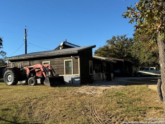 view of property exterior with a carport and a lawn