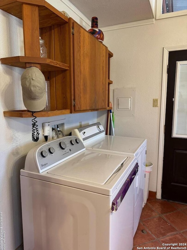 laundry room with cabinets, a textured ceiling, washer and clothes dryer, and crown molding