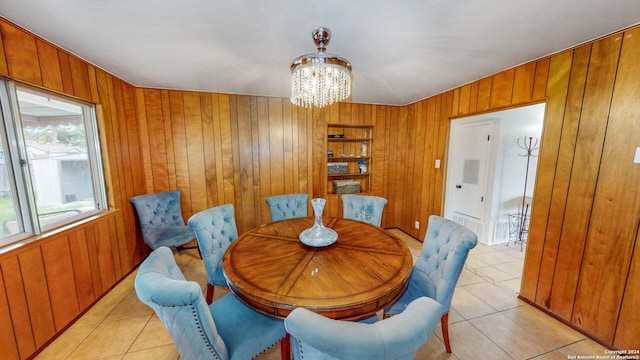 tiled dining space with an inviting chandelier and wood walls