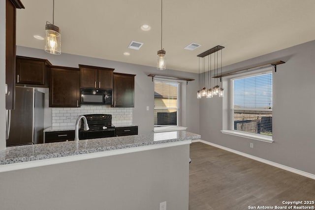 kitchen featuring black appliances, visible vents, and pendant lighting