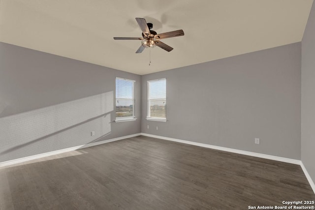 unfurnished room with ceiling fan, dark wood finished floors, and baseboards