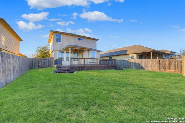 rear view of property featuring a fenced backyard, a deck, and a yard