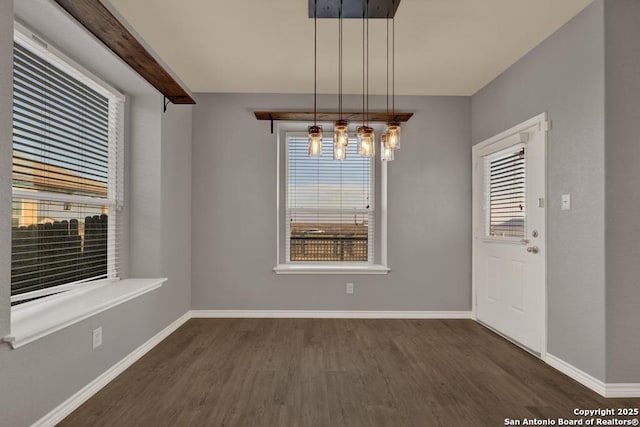 unfurnished dining area with plenty of natural light, baseboards, and dark wood-type flooring