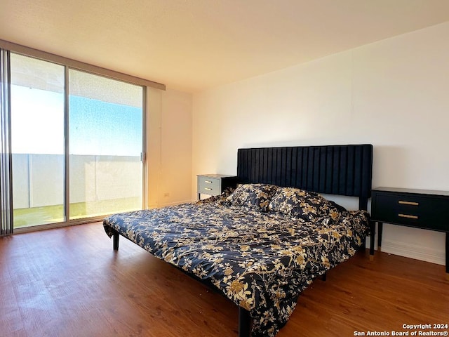 bedroom with wood-type flooring and access to outside