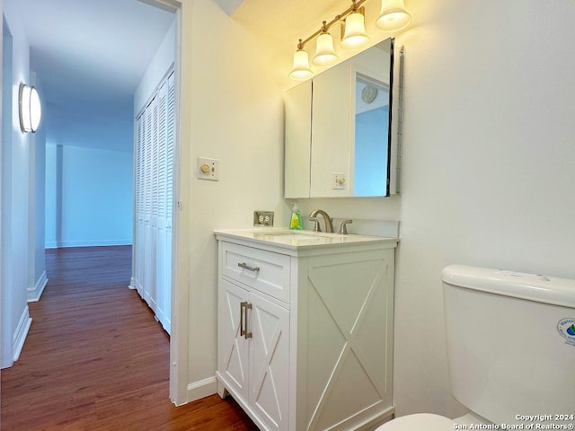 bathroom featuring vanity, hardwood / wood-style flooring, and toilet