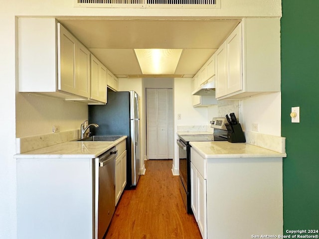 kitchen with electric range, dishwasher, white cabinets, and range hood