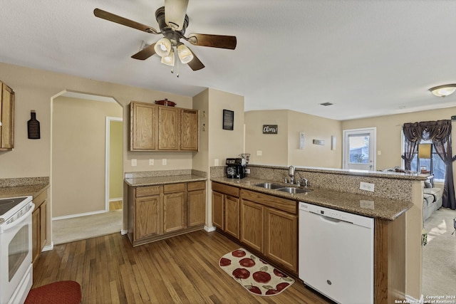 kitchen with white appliances, sink, hardwood / wood-style flooring, ceiling fan, and kitchen peninsula