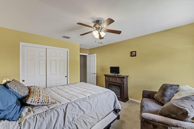 carpeted bedroom with ceiling fan and a closet