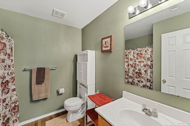 bathroom with hardwood / wood-style floors, vanity, and toilet