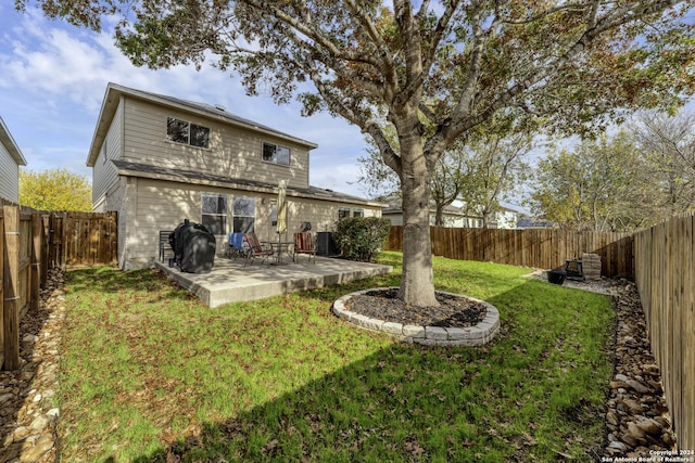 rear view of house featuring a lawn, central AC unit, and a patio