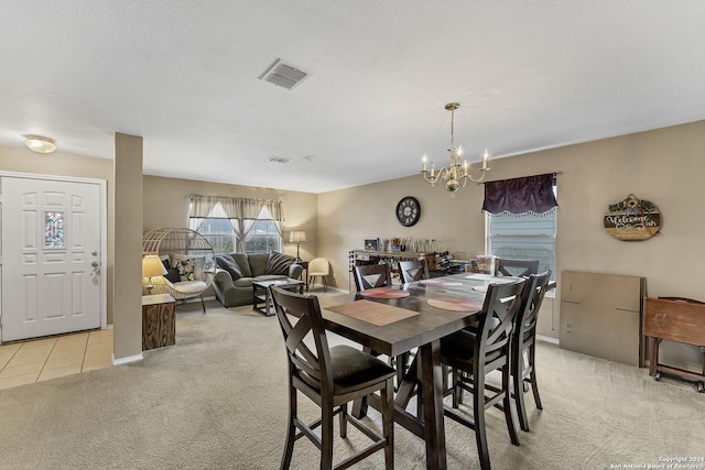 dining room with light colored carpet, a textured ceiling, and a notable chandelier