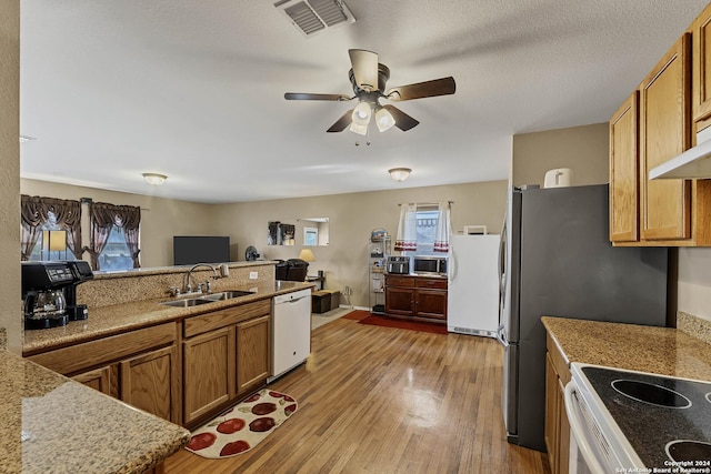 kitchen with white appliances, sink, hardwood / wood-style flooring, ceiling fan, and a textured ceiling