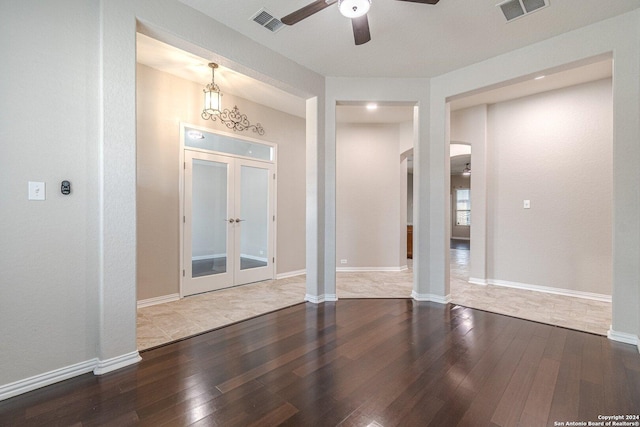 interior space with ceiling fan with notable chandelier, wood-type flooring, and french doors