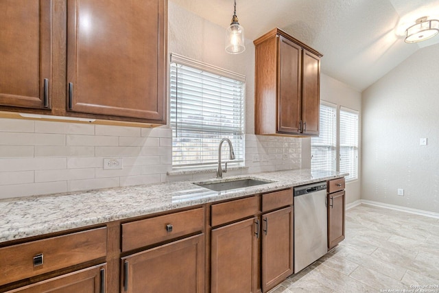 kitchen with sink, hanging light fixtures, light stone counters, stainless steel dishwasher, and lofted ceiling