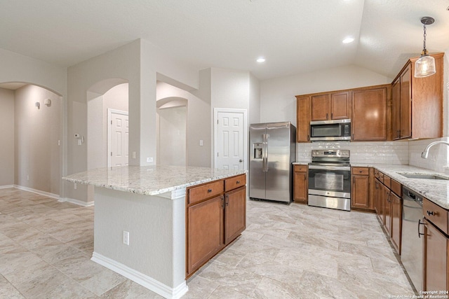 kitchen featuring sink, a center island, hanging light fixtures, lofted ceiling, and appliances with stainless steel finishes