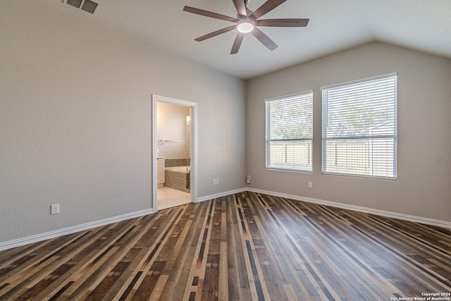 unfurnished room featuring dark hardwood / wood-style flooring, vaulted ceiling, a wealth of natural light, and ceiling fan