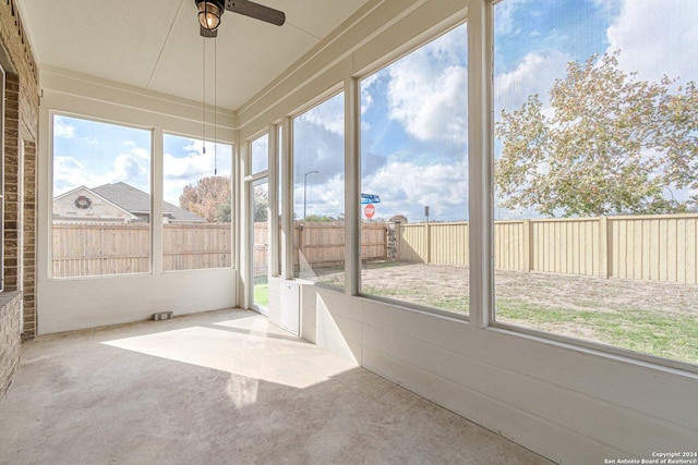 unfurnished sunroom with ceiling fan