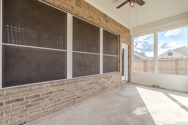 unfurnished sunroom with ceiling fan