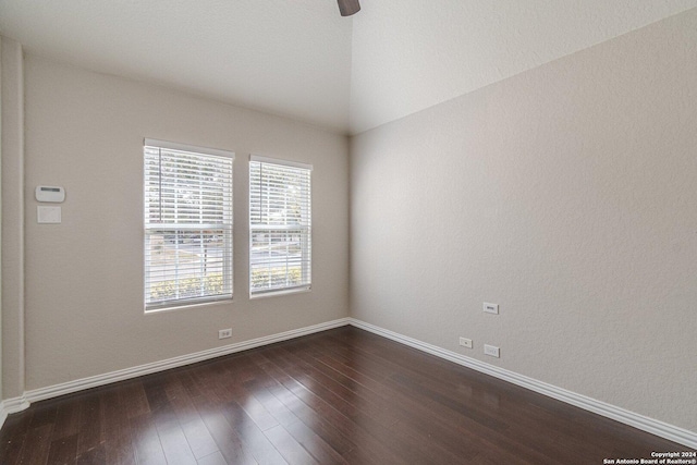 empty room featuring dark hardwood / wood-style flooring and vaulted ceiling