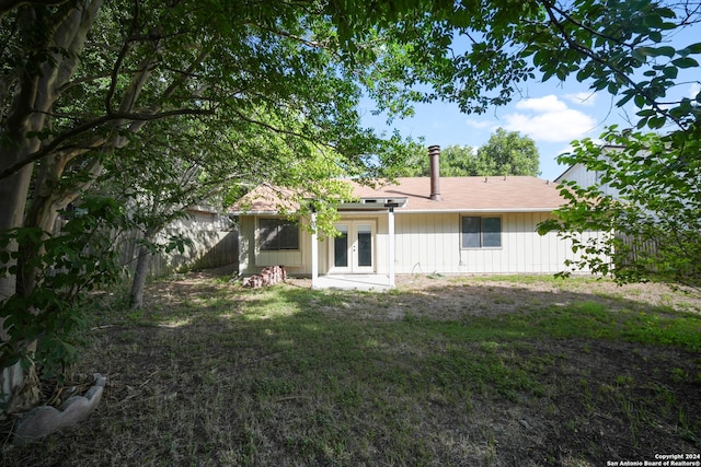 back of property featuring a lawn and french doors