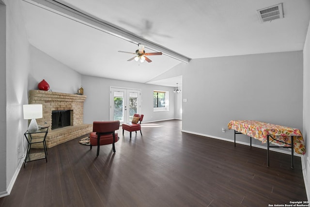 sitting room featuring ceiling fan, french doors, dark wood-type flooring, vaulted ceiling with beams, and a fireplace