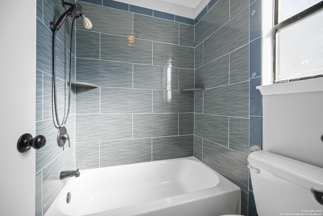 bathroom with toilet and tiled shower / bath