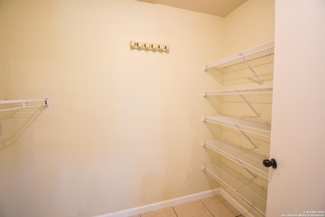 walk in closet with light tile patterned floors