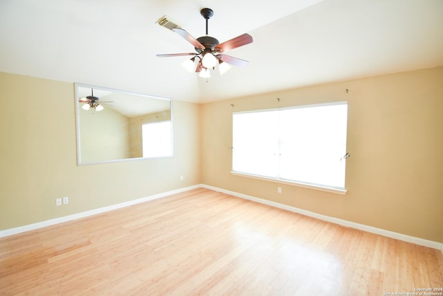 unfurnished room with ceiling fan, lofted ceiling, and light wood-type flooring