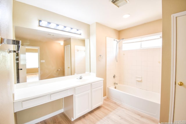 bathroom with vanity, wood-type flooring, and tiled shower / bath