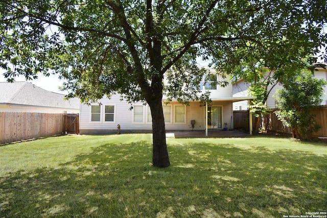 rear view of property featuring a lawn and a patio