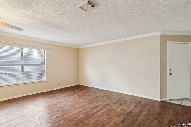 empty room with dark wood-type flooring, a textured ceiling, and ornamental molding