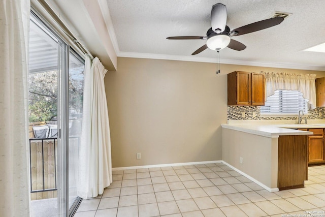 interior space with ceiling fan, crown molding, light tile patterned floors, and a textured ceiling