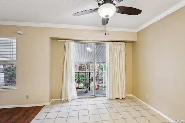 tiled spare room featuring a textured ceiling, ceiling fan, and ornamental molding